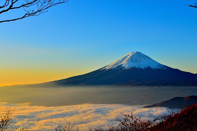 Mt. Fuji over a cloudy white sky and a sunrise